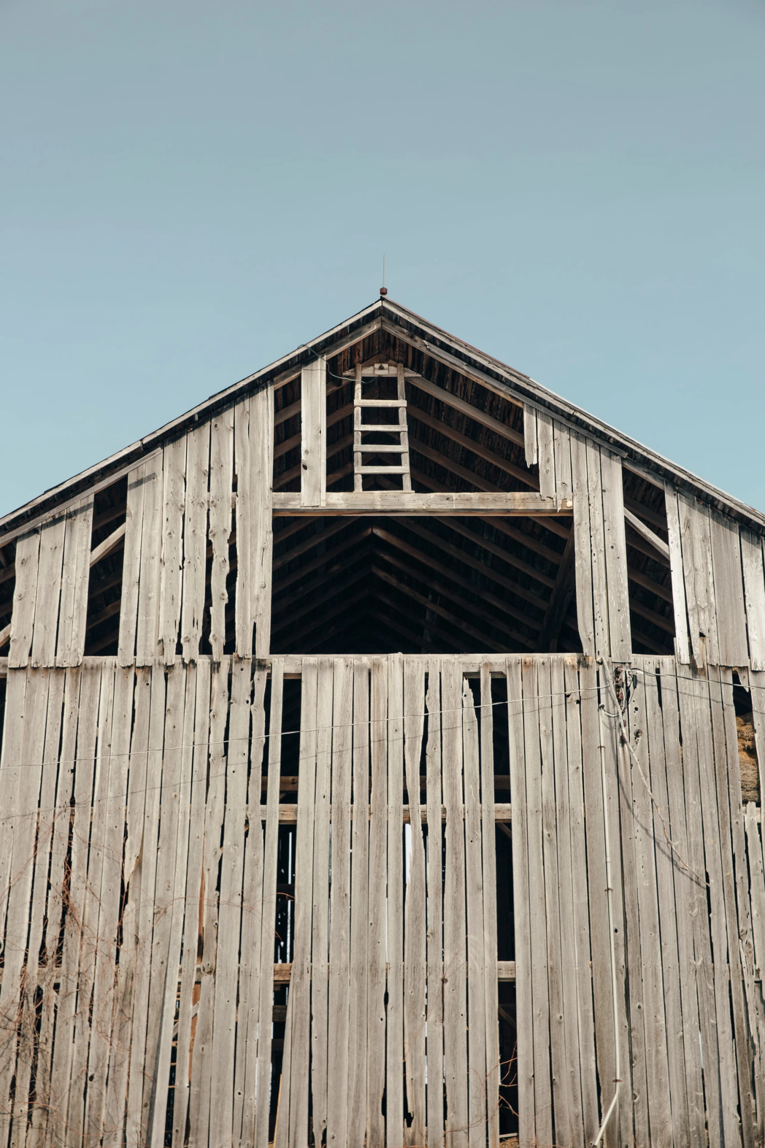 a tall wooden building has two windows and a door