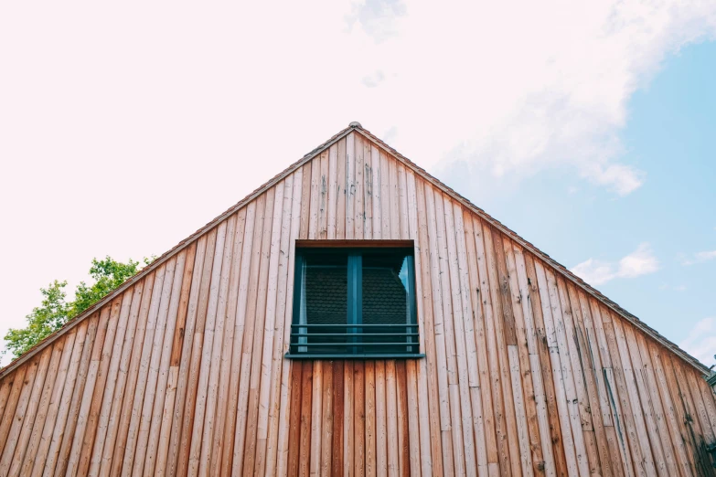 the corner of a brown building with a wooden frame and window