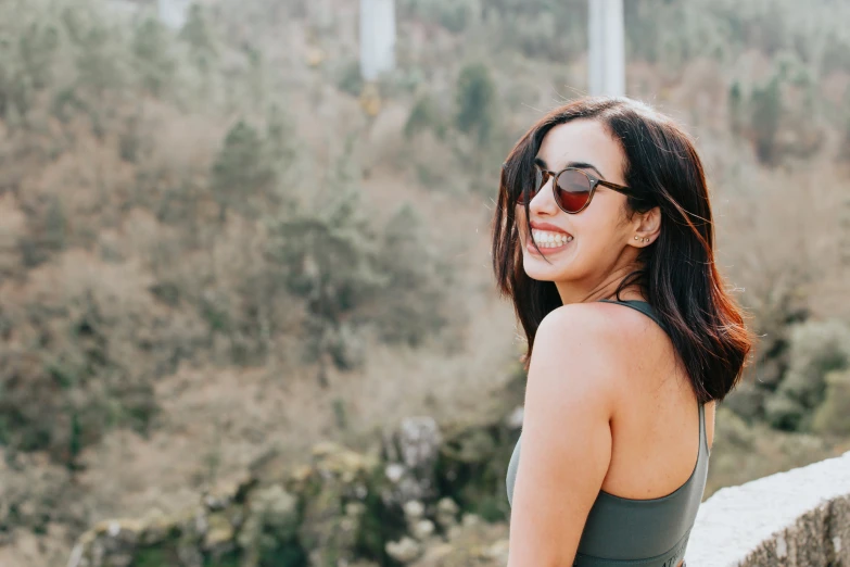 smiling woman in green dress on the bridge overlooking the water