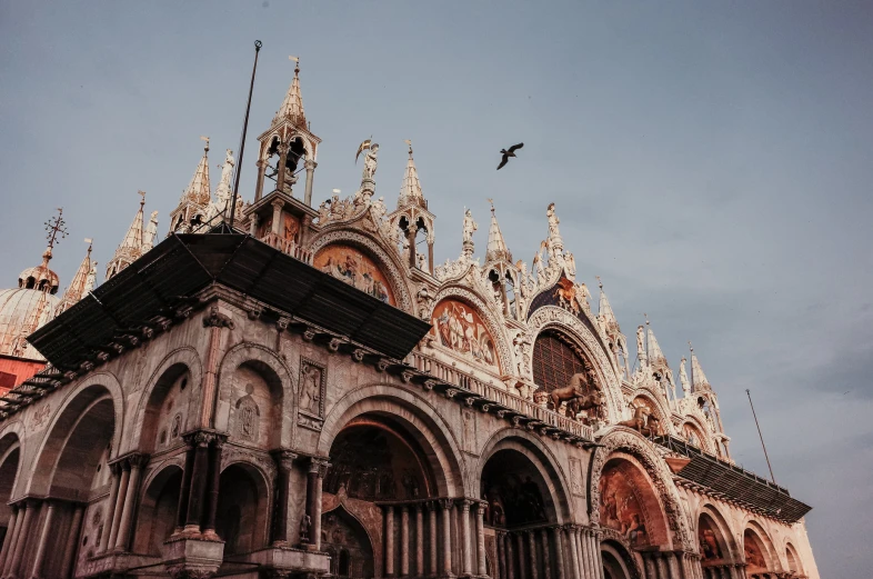 the front of an old building in front of a cloudy sky