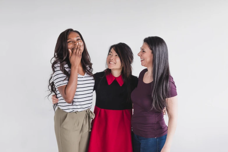 a group of women standing next to each other with their hands together