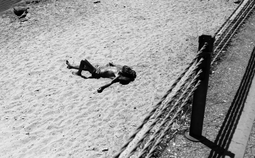 a black and white image of a man falling in the sand