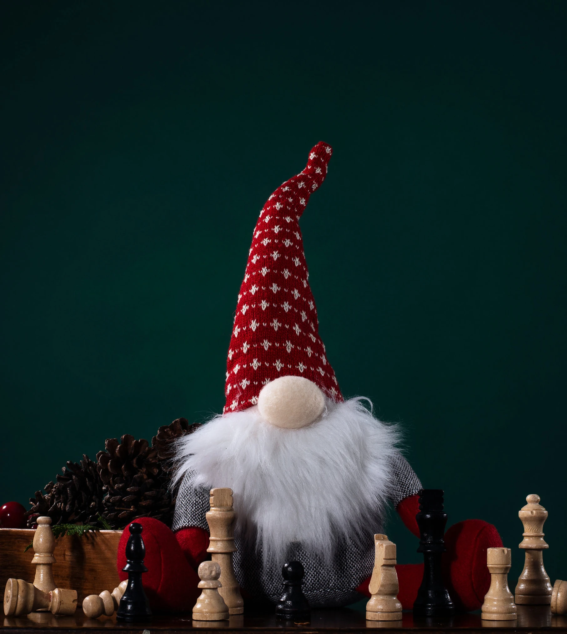 a gnome sits with chess pieces in front of them