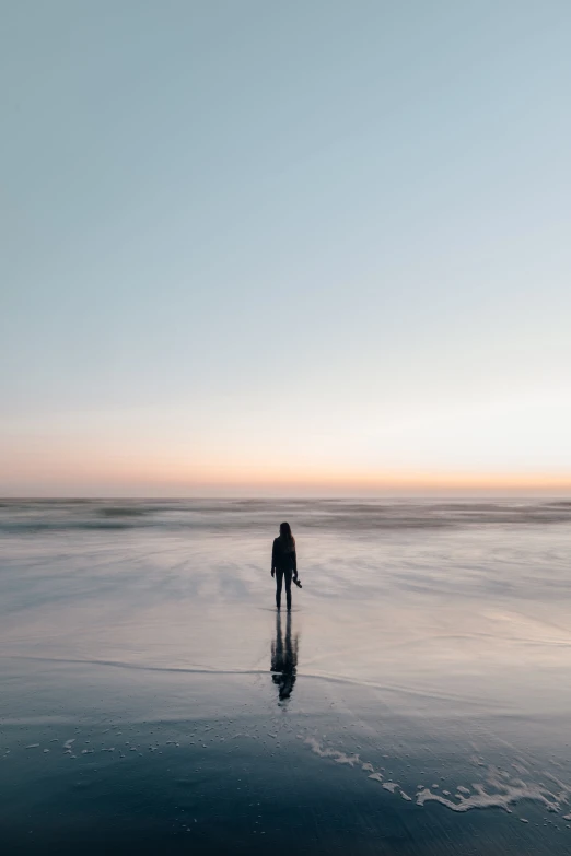 a person standing on the beach in the sand