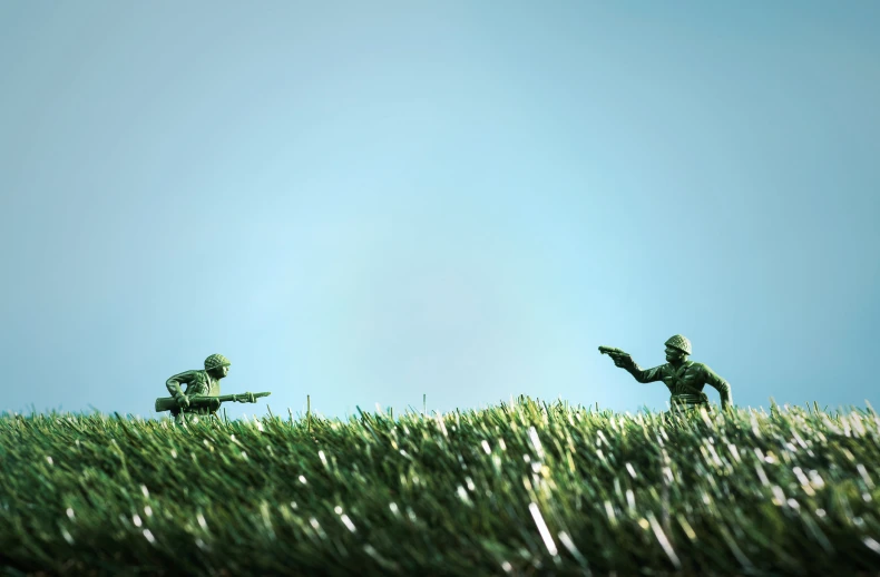a 3d illustration of two green soldiers walking on a grassy field