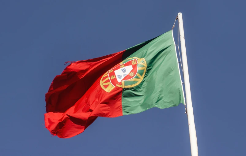 a portugal flag on a pole in the wind