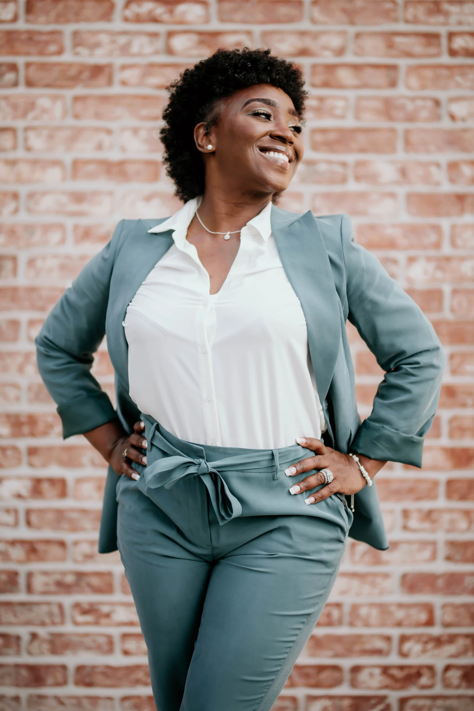 a smiling woman in blue pants and jacket poses for a picture