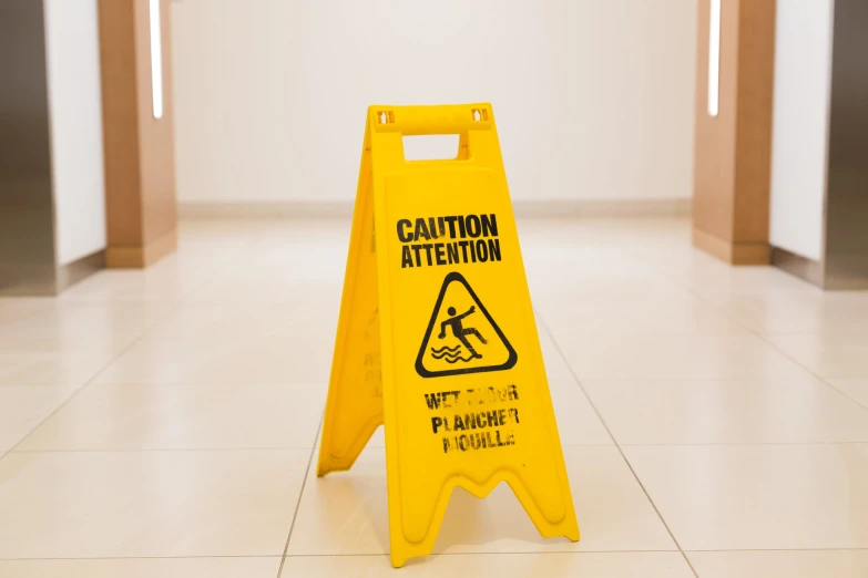 the caution sign is yellow on the floor