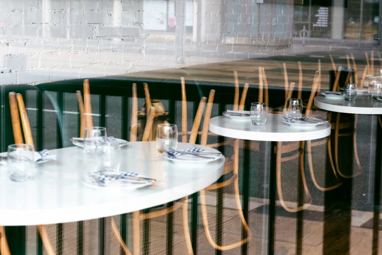 some chairs and tables behind a glass front