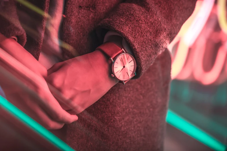 a person holding a pink watch in their hands
