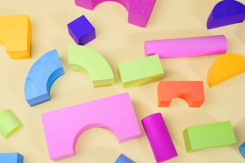 a group of multicolored wooden block shapes next to a wall