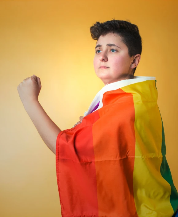 a young man wearing a colorful cape over his head