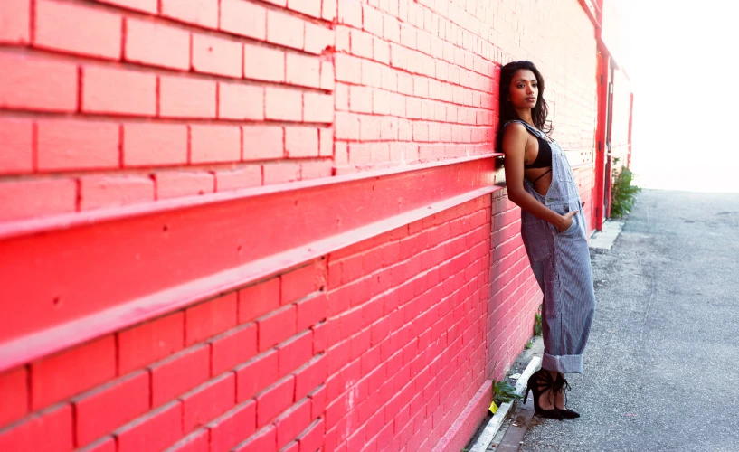 a woman is standing outside by the wall