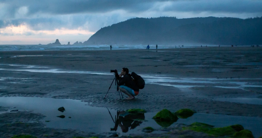 the surfer is holding his surfboard on the beach