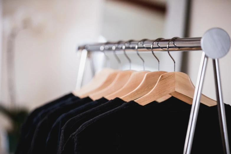 a bunch of shirts hanging from the clothes rail