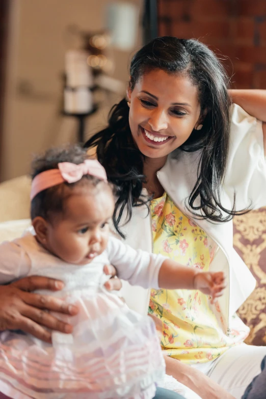 a smiling woman holding a little girl