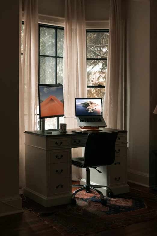 an office desk with an open laptop computer