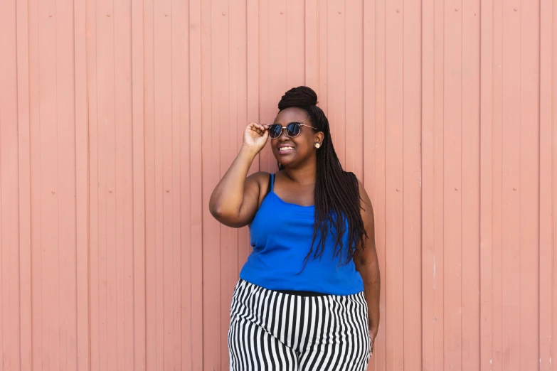 a young woman is smiling and wearing striped shorts