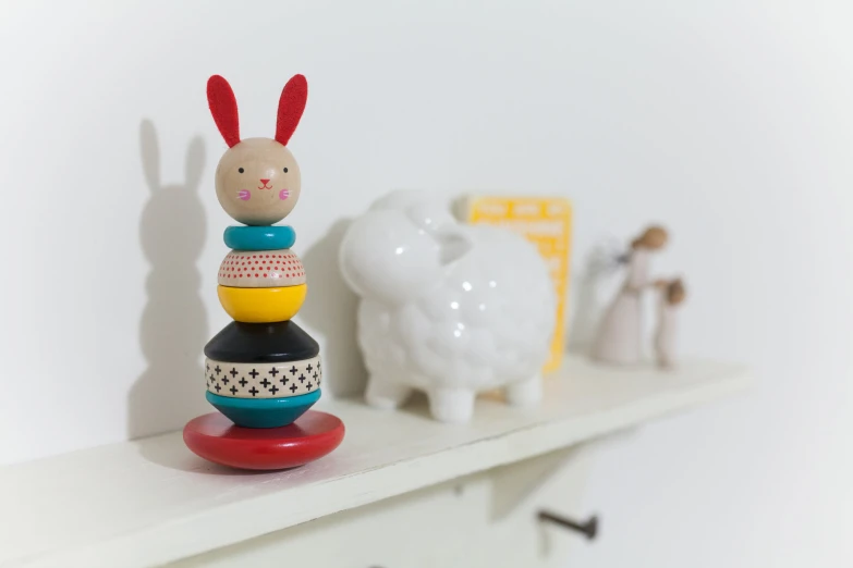 a stack of toys sitting on top of a white shelf