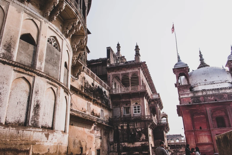 a woman walking down an alley between old buildings