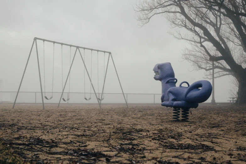 a swing set and some swings in the fog