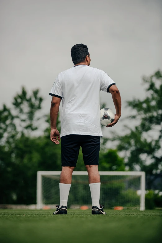 a man wearing a soccer uniform looking at the ball