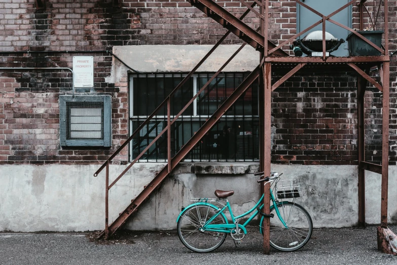 a bicycle leaning against a building near a window