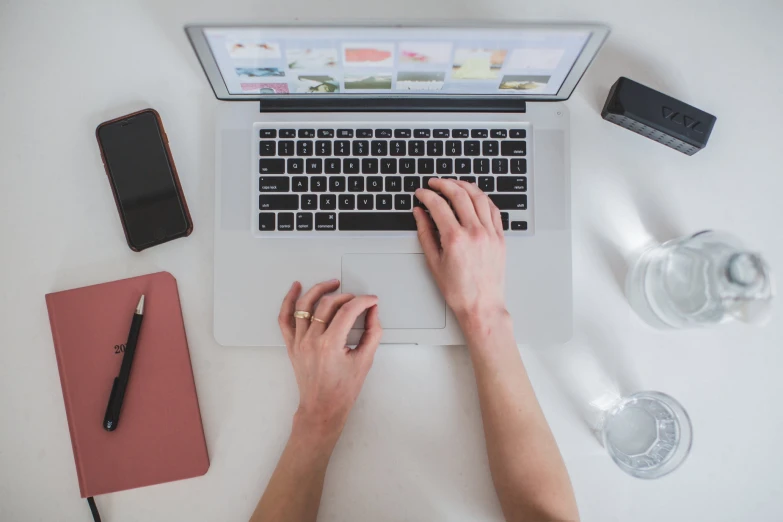 a person using a laptop computer while typing on it