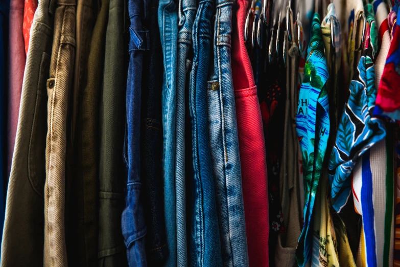 an assortment of clothing hanging up in a closet