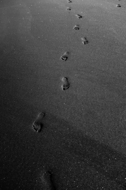 a black and white po of footprints in the sand