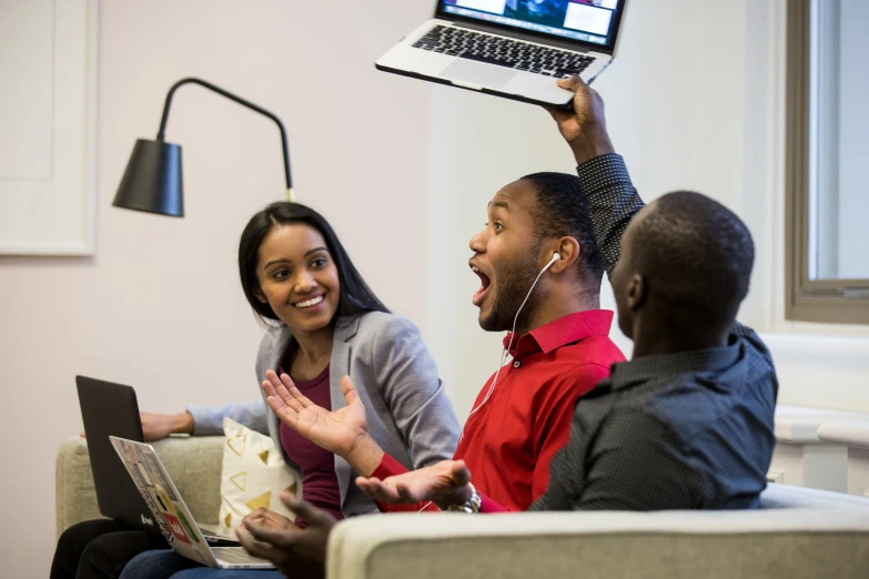 a woman is holding up a laptop screen and laughing