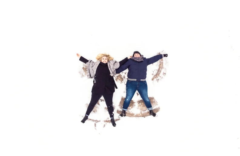 two people in the snow and one has his arms up