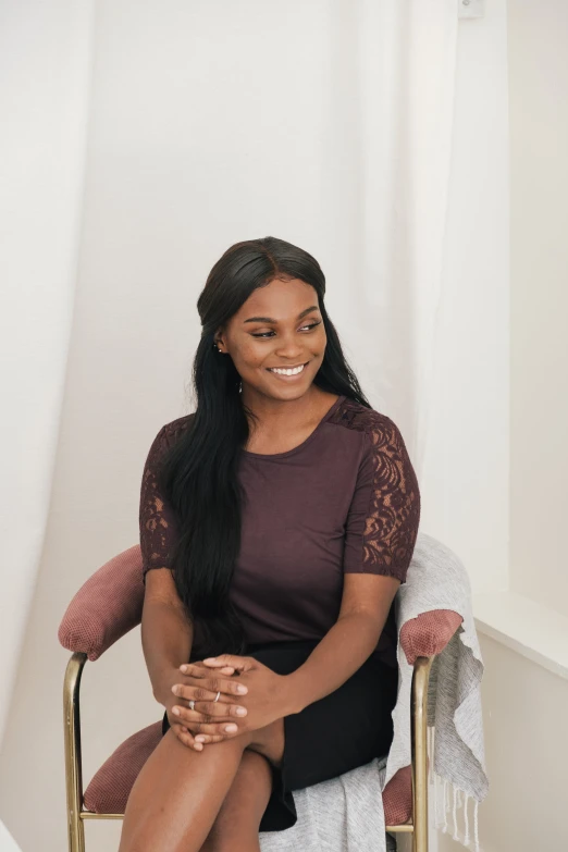 the woman is sitting on a chair with her legs crossed