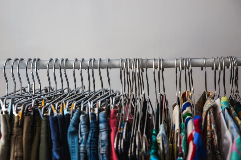 many jackets are lined up on the rails