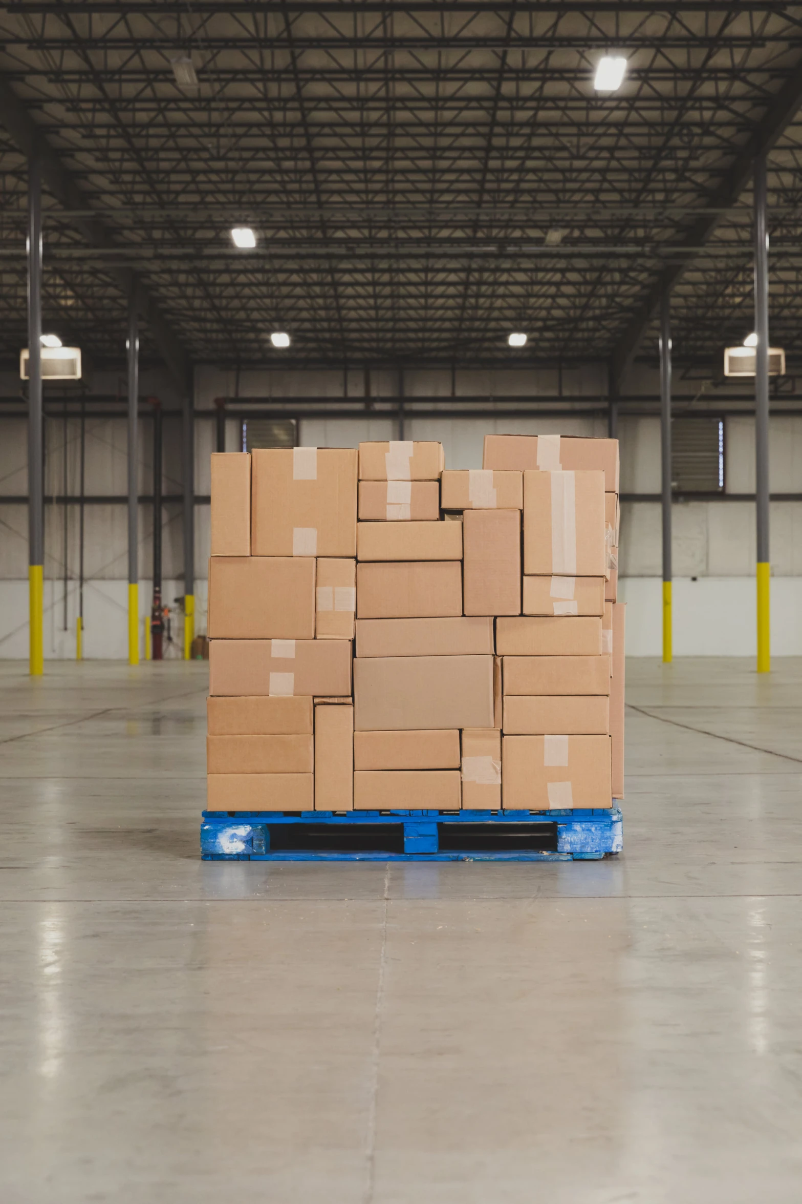 a large stack of boxes on a blue stand in a warehouse