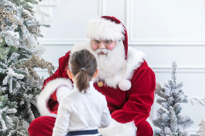 a little girl sitting on santa clause chair