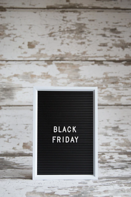 a black friday sign is placed on top of the wooden surface