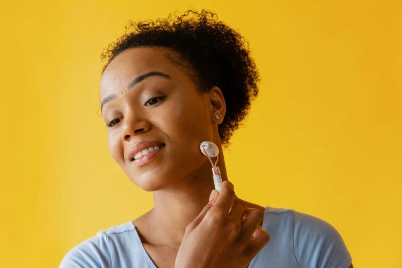 the woman is holding the brush to her face