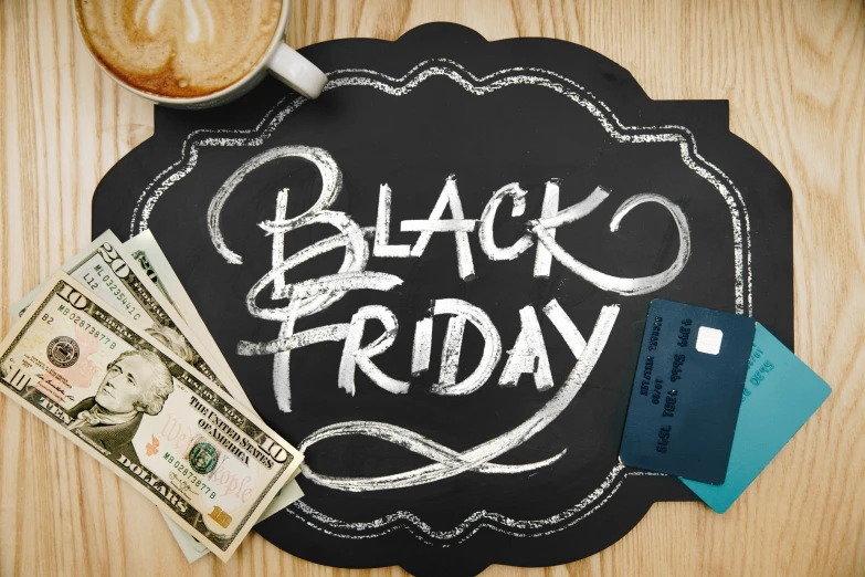 a chalkboard that says black friday is next to money and card