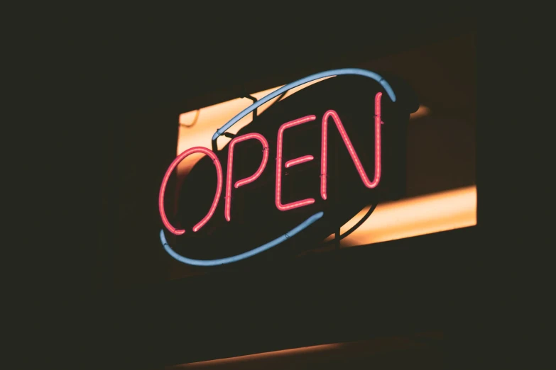 a neon open sign on the outside of a building