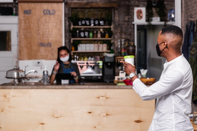 two people behind a bar taking food from a container