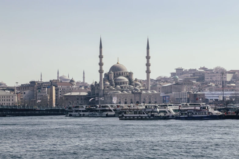 a busy harbor in a city with boats moored in front of it