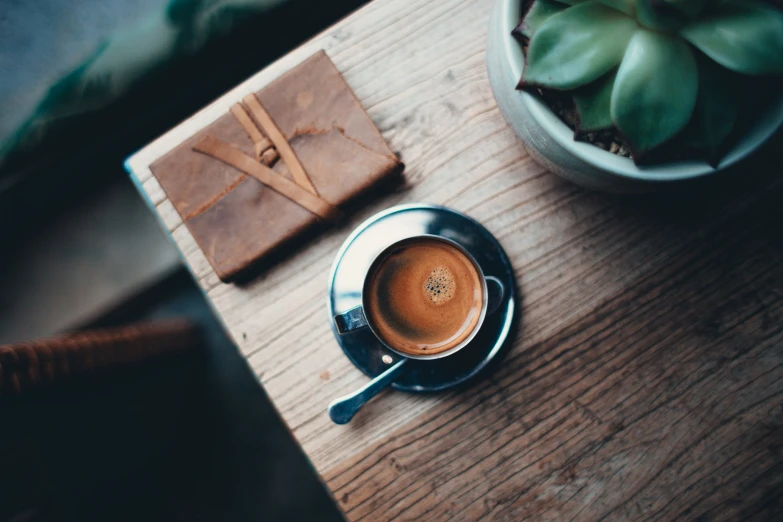 a cup of coffee sitting on top of a wooden table