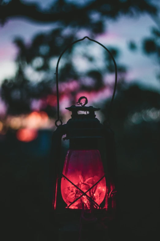 a red lit lantern is set on an iron stand with chains