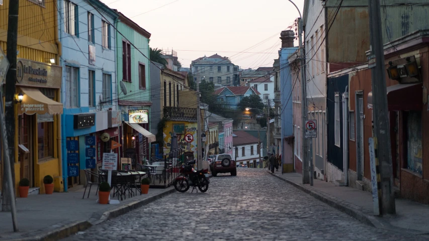 a narrow brick city street with a couple bicyclists