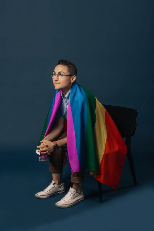 a man with a colored scarf sitting on a chair