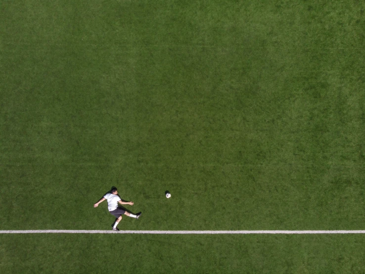 a man is running toward a ball on the green grass