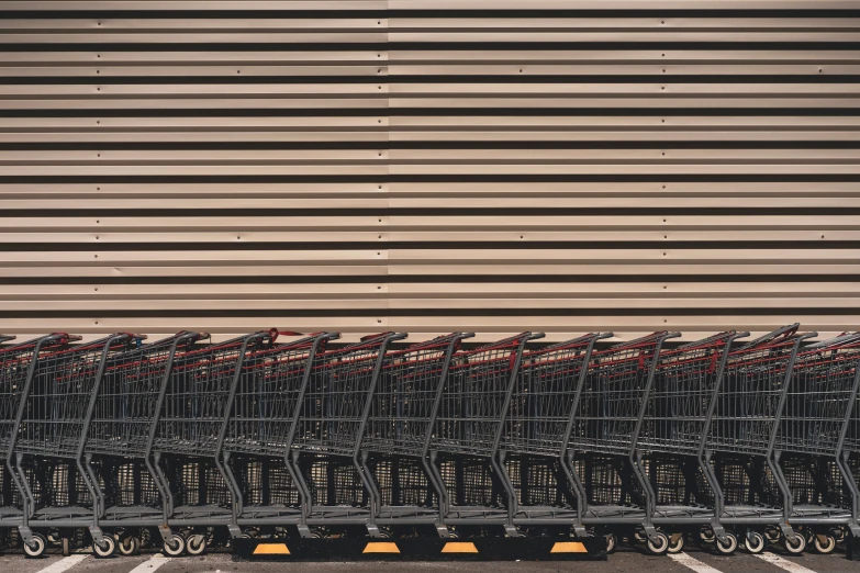 a row of shopping carts lined up near a large building