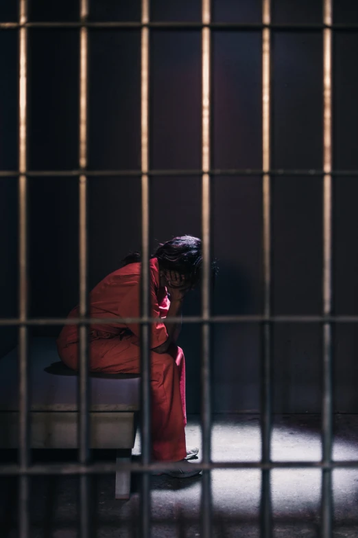 the back of a person's head through bars of  cell