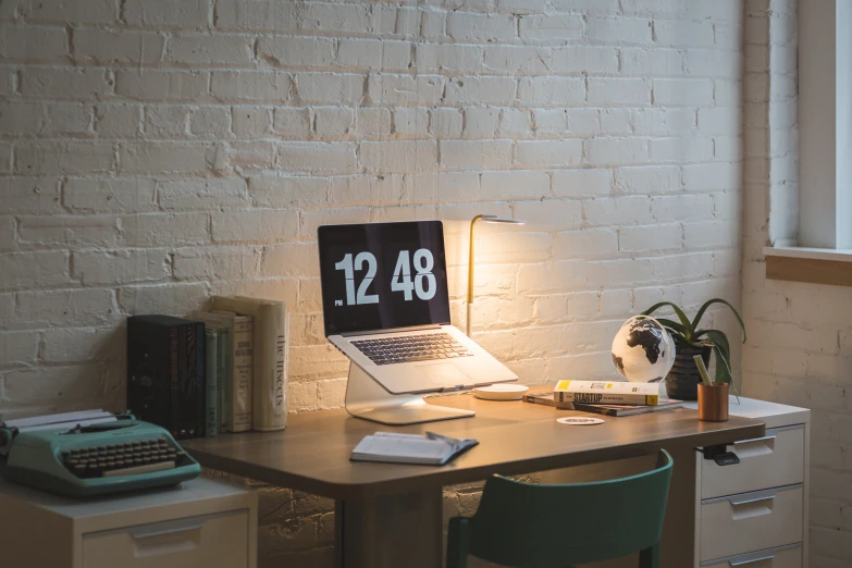 a desk with a laptop computer and office supplies on it